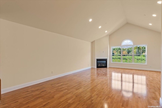 35 Steven Cir Unit 35, Dix Hills, NY 11746 - unfurnished living room featuring a glass covered fireplace, recessed lighting, light wood finished floors, and high vaulted ceiling