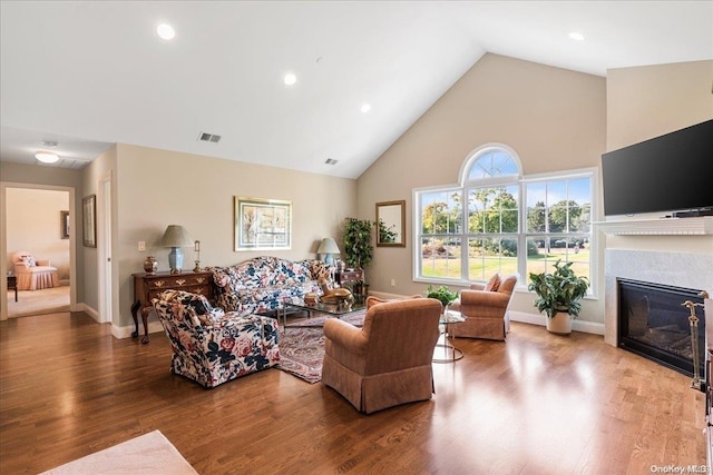35 Steven Cir Unit 35, Dix Hills, NY 11746 - living area with high vaulted ceiling, a glass covered fireplace, wood finished floors, and recessed lighting