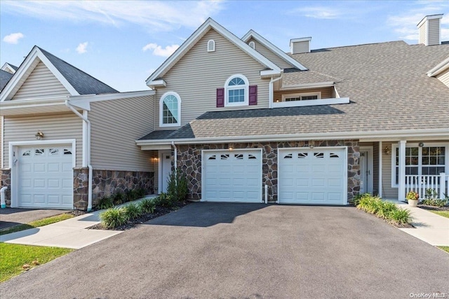 35 Steven Cir Unit 35, Dix Hills, NY 11746 - view of front facade with stone siding, driveway, a chimney, and roof with shingles