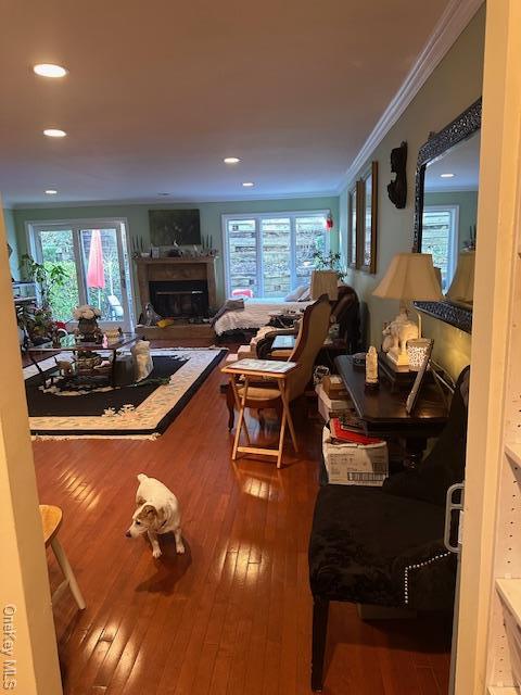 living room featuring hardwood / wood-style flooring, plenty of natural light, and crown molding