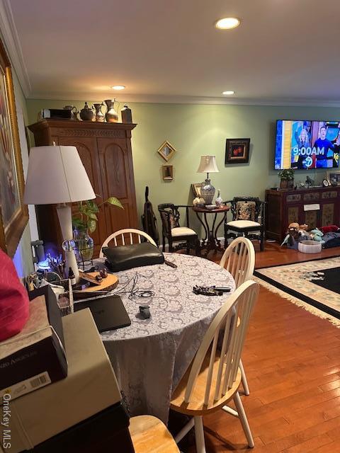 dining space with light hardwood / wood-style flooring and crown molding