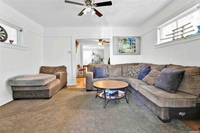 living room featuring carpet, a textured ceiling, and ceiling fan