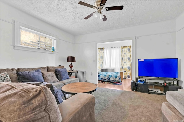 living room with ceiling fan, hardwood / wood-style floors, a textured ceiling, and radiator heating unit