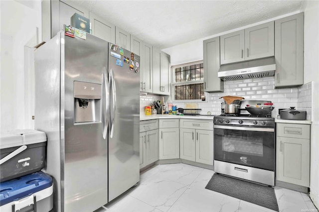 kitchen with gray cabinetry, decorative backsplash, a textured ceiling, and appliances with stainless steel finishes