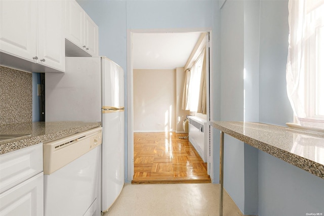 kitchen with backsplash, a wealth of natural light, dishwasher, and white cabinets