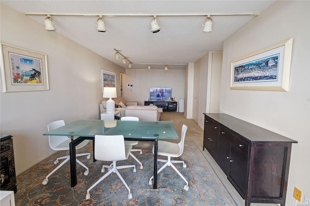 carpeted dining area featuring track lighting