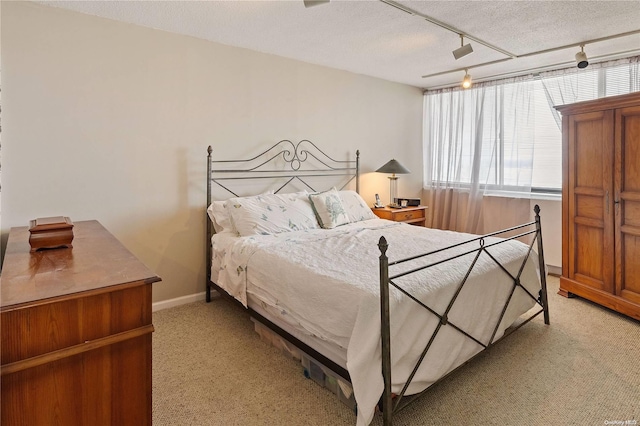 carpeted bedroom featuring a textured ceiling, ceiling fan, and rail lighting