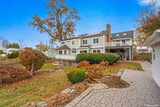 26 Bayville Park Blvd, Bayville, NY 11709 - back of house featuring stairway, a patio area, a chimney, a wooden deck, and solar panels