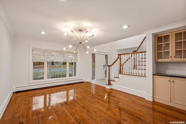 26 Bayville Park Blvd, Bayville, NY 11709 - unfurnished living room with stairway, a chandelier, wood finished floors, a baseboard heating unit, and crown molding