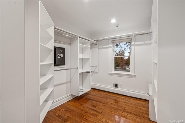 spacious closet with hardwood / wood-style floors and baseboard heating