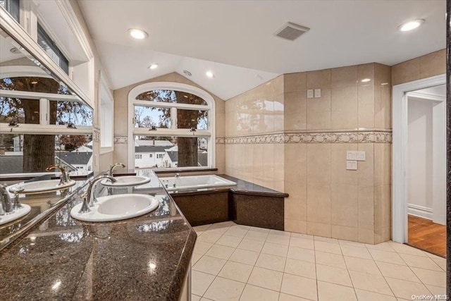 bathroom with a bathing tub, wood-type flooring, lofted ceiling, vanity, and tile walls