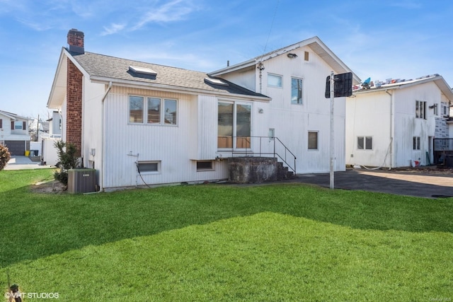 back of house featuring a lawn and central air condition unit