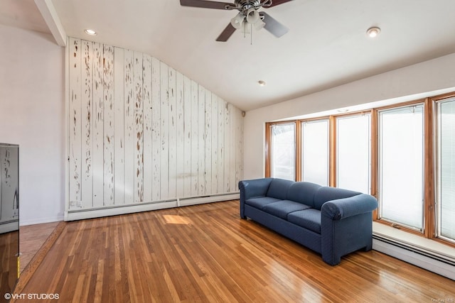 living room with baseboard heating, ceiling fan, lofted ceiling, and wood-type flooring