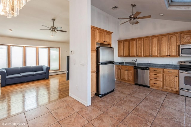 kitchen featuring light tile patterned floors, ceiling fan, baseboard heating, and appliances with stainless steel finishes