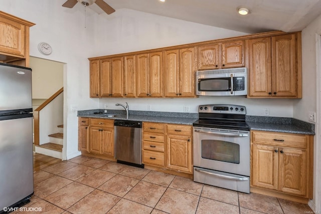 kitchen featuring lofted ceiling, sink, light tile patterned floors, ceiling fan, and stainless steel appliances