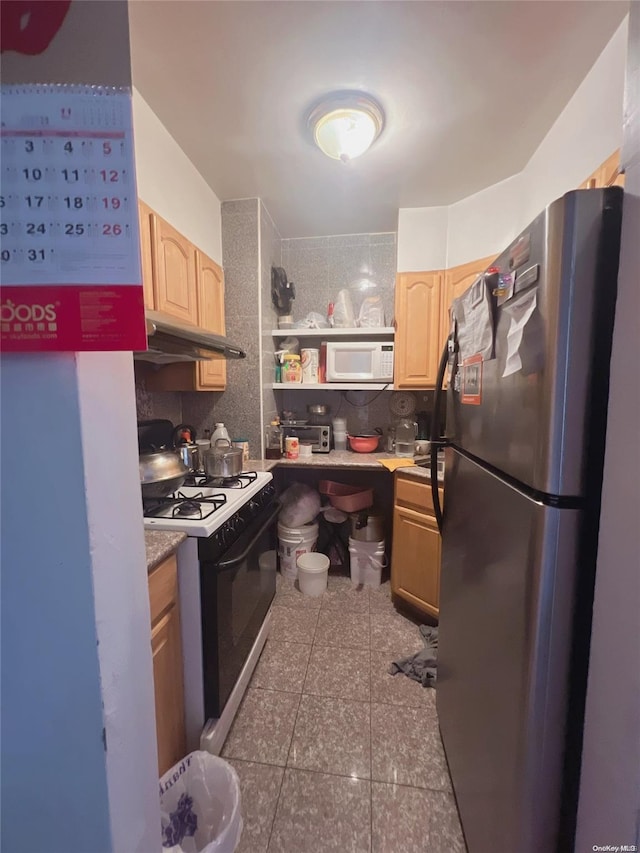 kitchen with light brown cabinets, white appliances, backsplash, and dark tile patterned floors