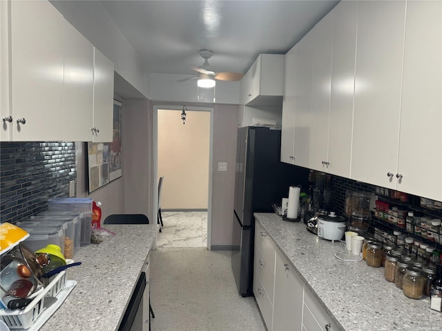 kitchen with white cabinets, decorative backsplash, ceiling fan, and light stone countertops