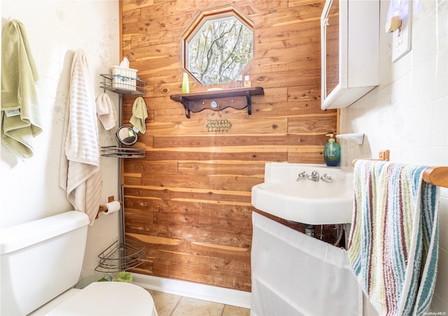 bathroom featuring toilet and wood walls