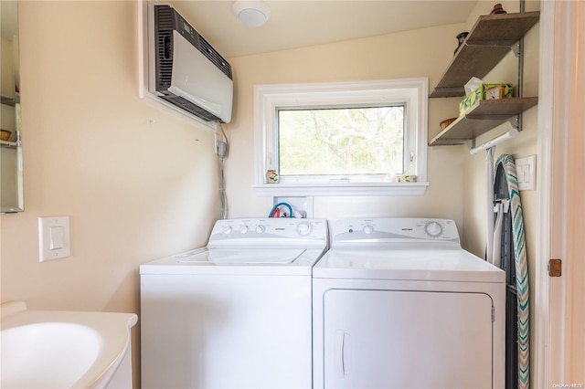 laundry room featuring washer and clothes dryer, an AC wall unit, and sink