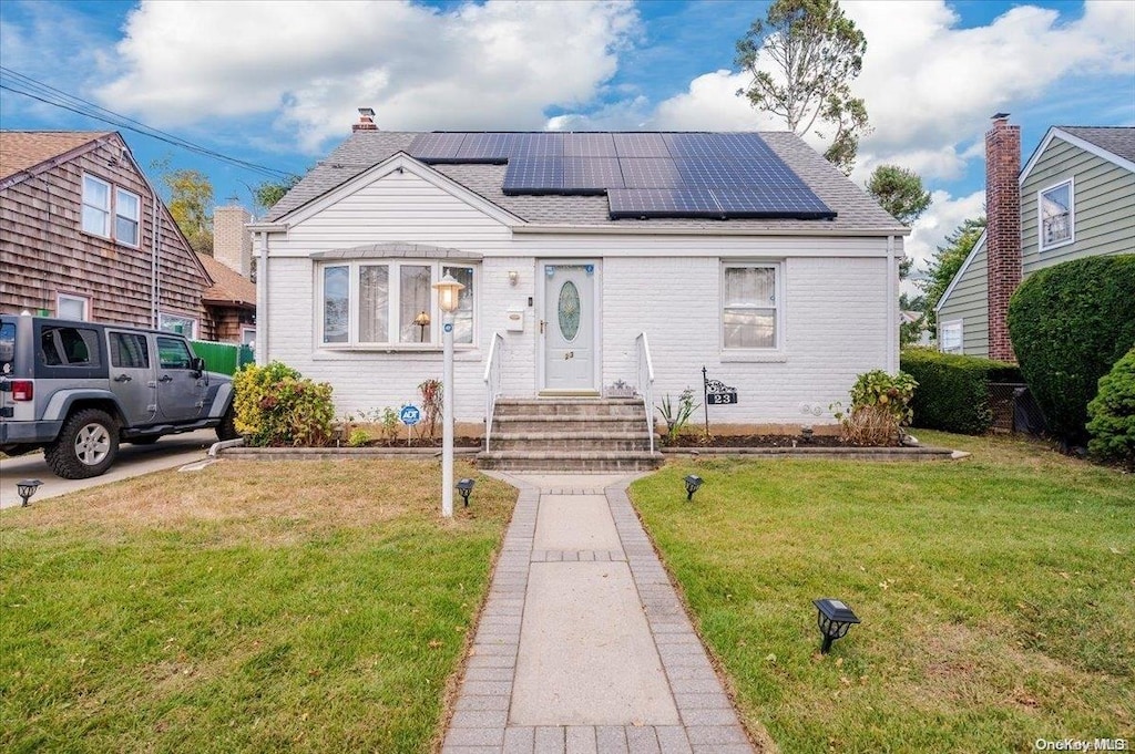 bungalow with solar panels and a front yard