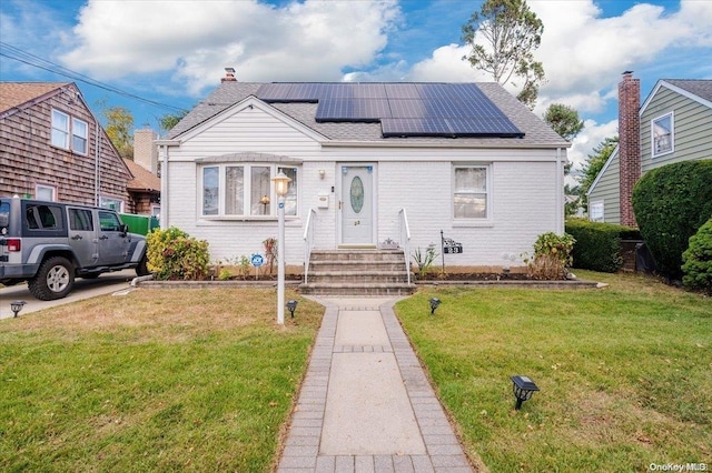 bungalow with solar panels and a front yard