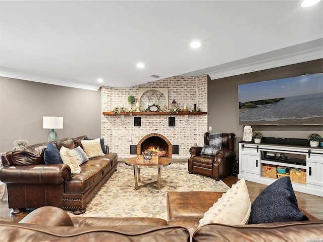 living room featuring hardwood / wood-style floors, a fireplace, and crown molding