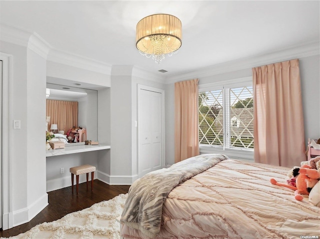 bedroom with dark hardwood / wood-style floors, crown molding, a chandelier, and a closet