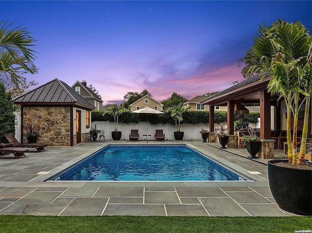 pool at dusk with a patio