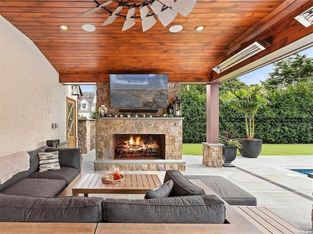 view of patio / terrace with an outdoor living space with a fireplace and ceiling fan