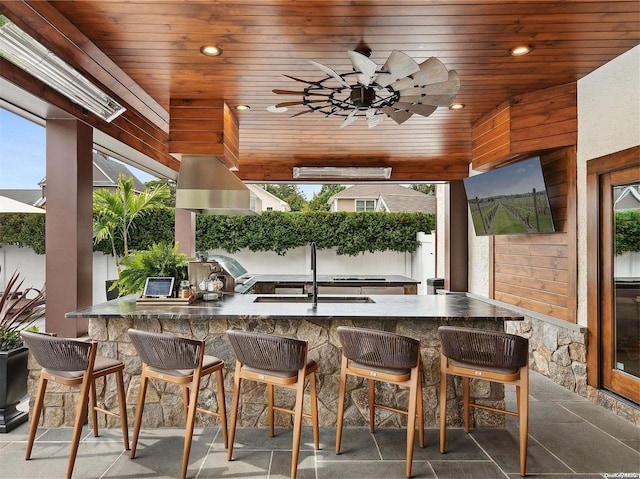 sunroom with ceiling fan, wood ceiling, and sink