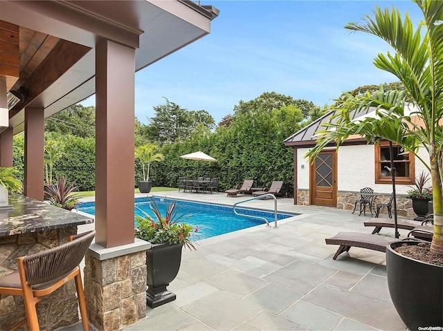 view of pool featuring a patio area and an outdoor bar