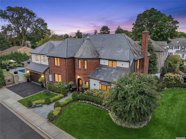 38 Royal Ct, Rockville Centre, NY 11570 - view of front of property featuring a high end roof, a garage, asphalt driveway, and a chimney