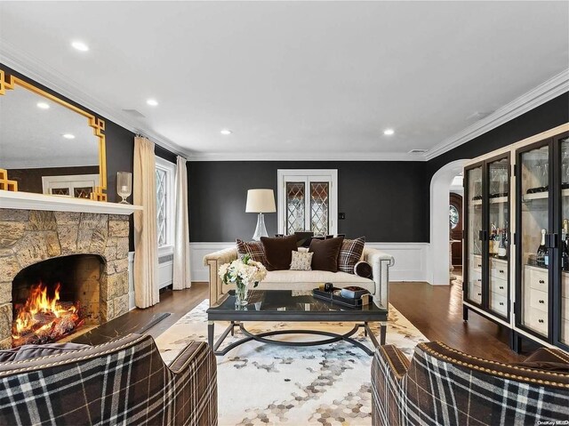 38 Royal Ct, Rockville Centre, NY 11570 - living area with a wainscoted wall, wood finished floors, crown molding, arched walkways, and a fireplace