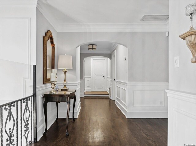 38 Royal Ct, Rockville Centre, NY 11570 - foyer entrance with crown molding, dark wood-style flooring, a wainscoted wall, arched walkways, and a decorative wall