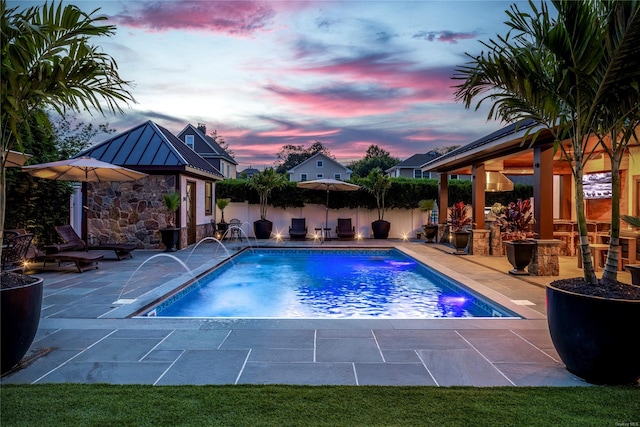 38 Royal Ct, Rockville Centre, NY 11570 - pool at dusk featuring a patio area