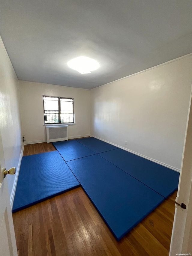 exercise area with dark hardwood / wood-style flooring and radiator