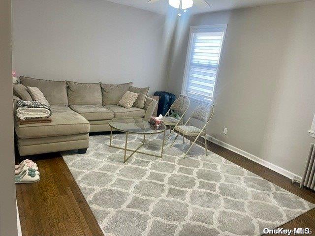 living room featuring hardwood / wood-style floors, radiator heating unit, and ceiling fan