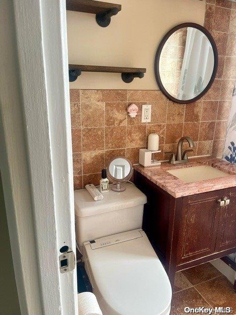 bathroom featuring vanity, tile patterned floors, tile walls, and backsplash