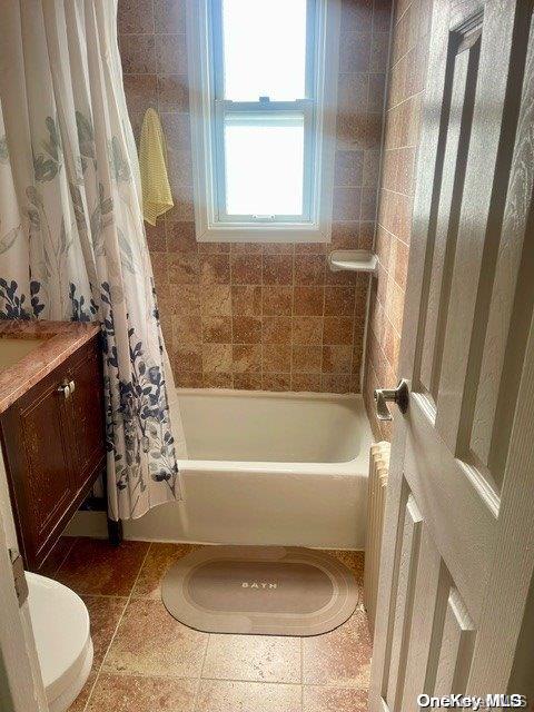 full bathroom featuring vanity, toilet, and shower / bath combo with shower curtain