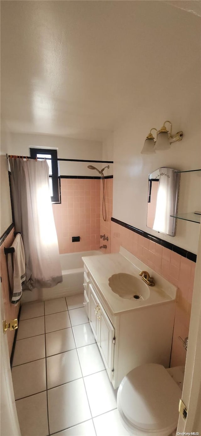 full bathroom featuring tile patterned floors, toilet, shower / tub combo with curtain, vanity, and tile walls