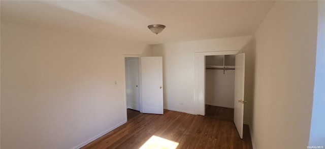 unfurnished bedroom featuring dark hardwood / wood-style floors and a closet