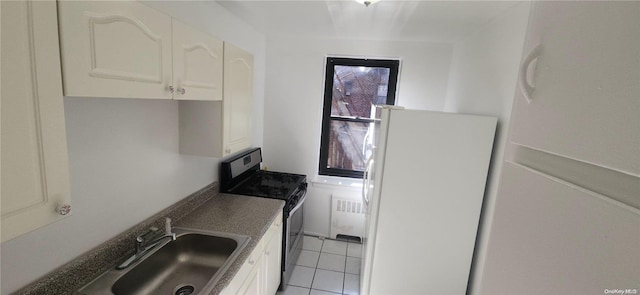 kitchen with stainless steel electric range, radiator, white refrigerator, sink, and white cabinetry