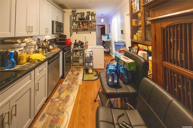 kitchen featuring stainless steel appliances, crown molding, light hardwood / wood-style floors, and gray cabinetry