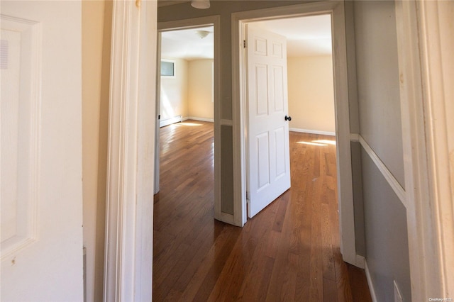 hallway with baseboard heating and dark wood-type flooring