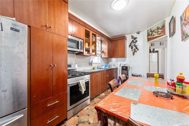 kitchen featuring decorative backsplash, sink, and stainless steel appliances