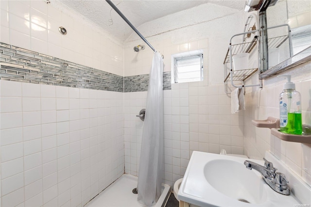 bathroom with a shower with curtain, a textured ceiling, and sink