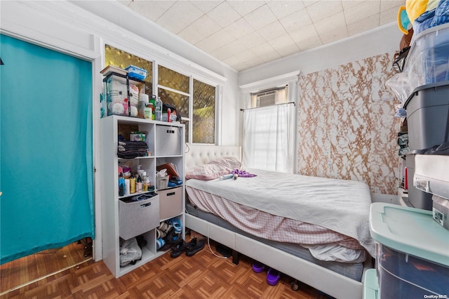 bedroom with dark parquet flooring and crown molding