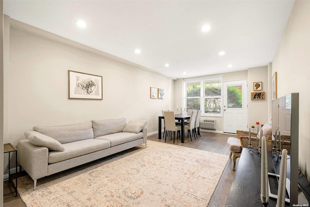 living room with hardwood / wood-style floors and a wall mounted air conditioner