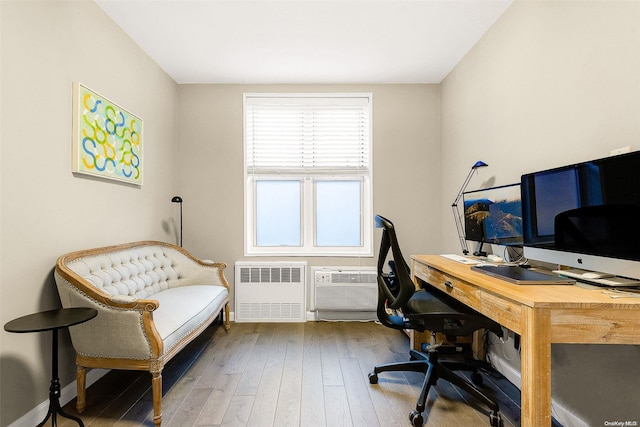 office space with hardwood / wood-style flooring, radiator, and a wall mounted AC