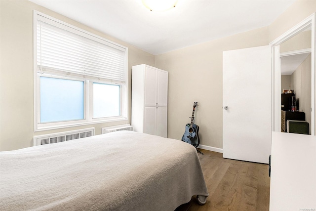 bedroom with light wood-type flooring and radiator